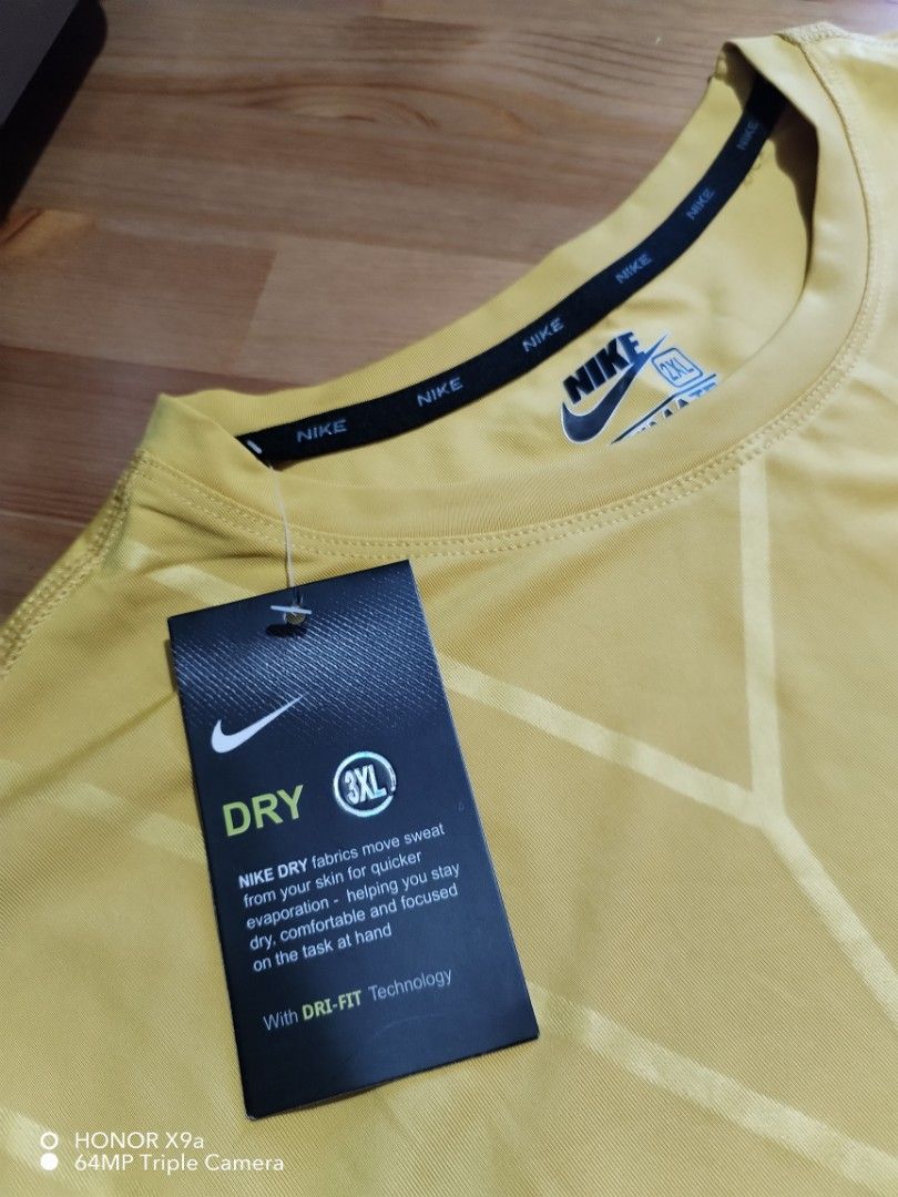 Nike Active Wear (Category: Activewear) located in Muntinlupa City. Submitted by arciagamaryann68 (Listing ID 1468102313, Image 2). Description: - Brand: Nike (Ultimate Tee / Active Wear) - Color: Mustard Yellow with subtle pattern and Nike logo design - Size: 2XL (Tagged 3XL on hang tag) - Material: 100% Polyester with Nike Dri-Fit technology for quick sweat evaporation - Condition: Brand new with tags attached - Features: Long sleeves, lightwei