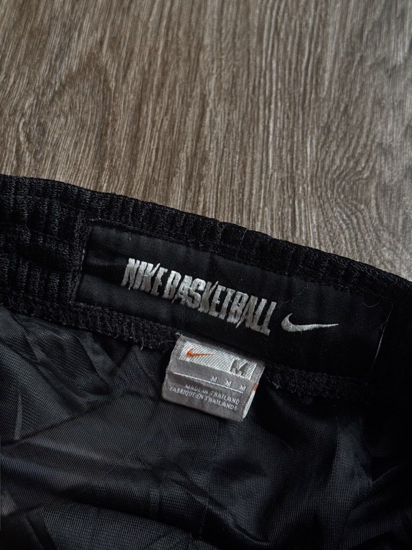 Nike baller short (Category: Shorts) located in Manila. Submitted by isseyboi (Listing ID 1468077741, Image 3). Description: - Brand: Nike - Style: Vintage basketball shorts - Color: Black with gold side stripes - Logo: Embroidered white Swoosh - Size: Medium (M) - Material: 100% polyester body and lining - Origin: Made in Thailand - Features: Elastic waistband with interior Nike Basketball branding tag, lightweight, breathable mesh texture.