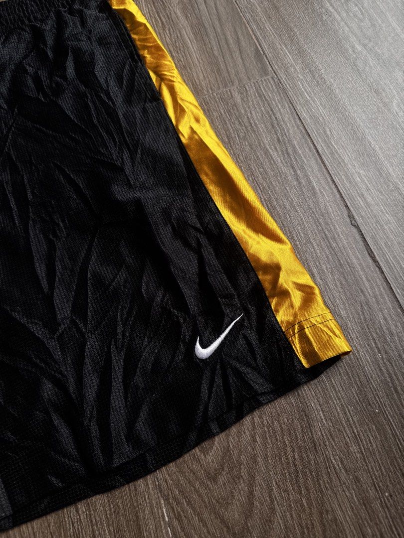 Nike baller short (Category: Shorts) located in Manila. Submitted by isseyboi (Listing ID 1468077741, Image 2). Description: - Brand: Nike - Style: Vintage basketball shorts - Color: Black with gold side stripes - Logo: Embroidered white Swoosh - Size: Medium (M) - Material: 100% polyester body and lining - Origin: Made in Thailand - Features: Elastic waistband with interior Nike Basketball branding tag, lightweight, breathable mesh texture.