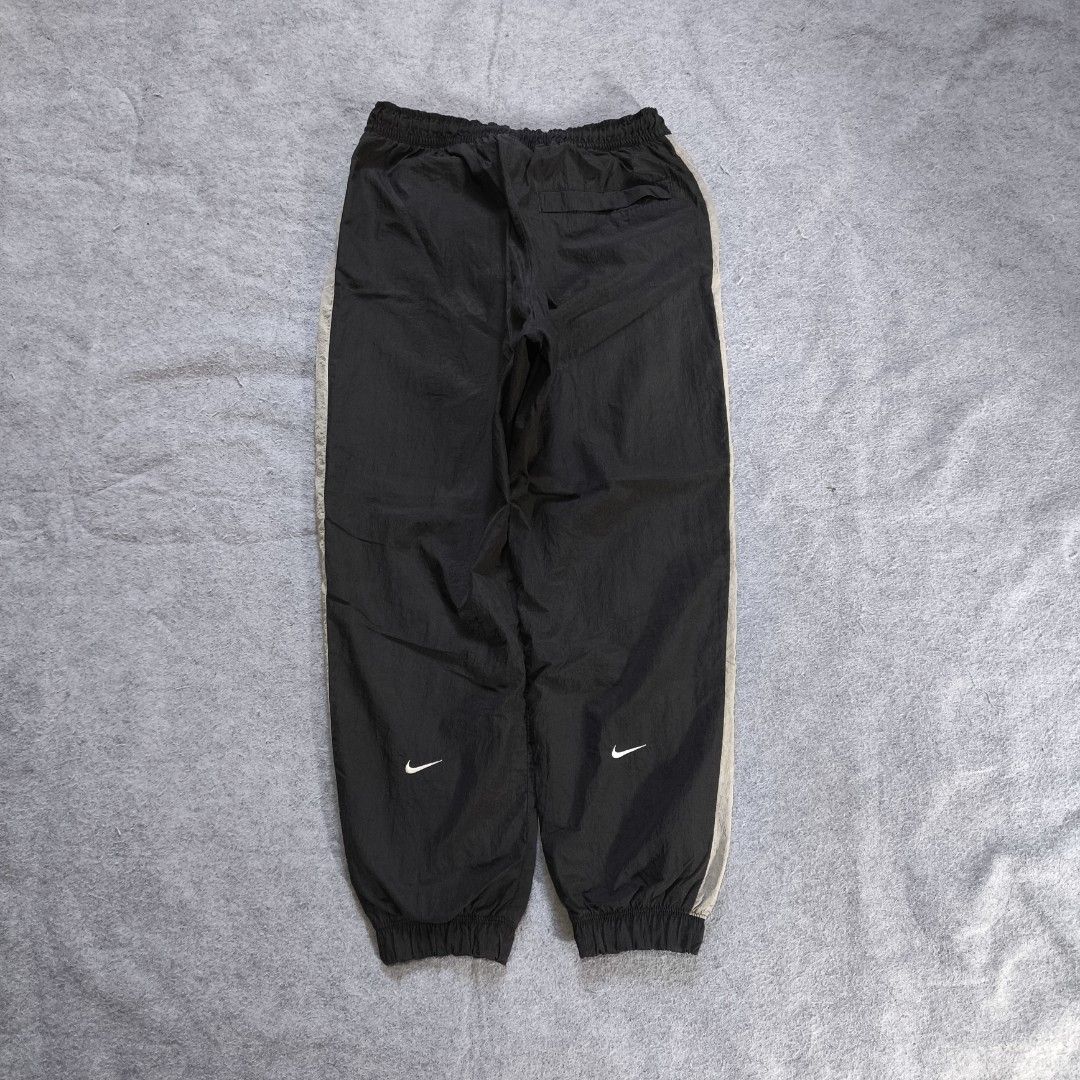 Nike Double Swoosh Nylon Track Pants (Category: Activewear) located in Manila. Submitted by shykes_26 (Listing ID 1468113618, Image 2). Description: Dimensions: Waist - 30-40 (M on tag) Length - 36.5 Thigh - 14 Leg open - 5 Issues: 1 Pinhole (not visible).