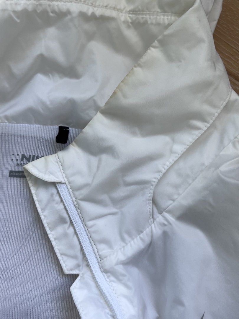 Nike Golf White Hooded Windbreaker Jacket Medium (Category: Coats, Jackets and Outerwear) located in Paranaque City. Submitted by PrelovedClosetetc (Listing ID 1468065401, Image 3). Description: - Brand: Nike Golf - Item: Hooded windbreaker / jacket - Color: White - Features: Full zip front, zippered side pockets, lightweight material - Condition: Good overall with smooth zippers and no rips/tears; has slight yellow discoloration around the insid