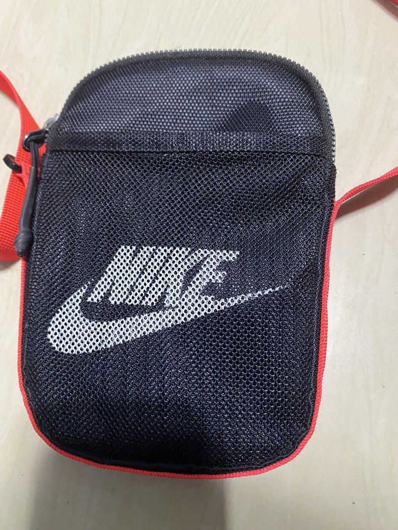 Nike Heritage Cross-Body bag (Category: Sling Bags) located in Manila. Submitted by callejage69430 (Listing ID 1468232668, Image 2). Description: Nike Heritage Cross-Body Bag (Small, 1L) in black with a bright red/neon orange strap.