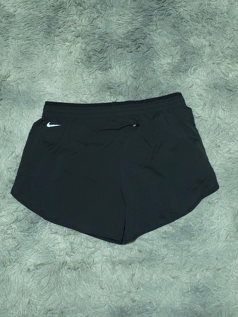 Nike Running Shorts Black With Purple Yellow Pattern (Category: Activewear) located in Abulug. Submitted by humanwhosellthings (Listing ID 1468184726, Image 2). Description: - Brand: Nike ✅Excellent Condition ✅Issue: none ▫️Waist Size: 30-38 ▫️Length: 12 - Color: Black with yellow and purple striped graphic pattern - Fit: Elastic waistband with branded drawstrings - Details: Small reflective swoosh logo on the front leg - Storage: Handy zipped po