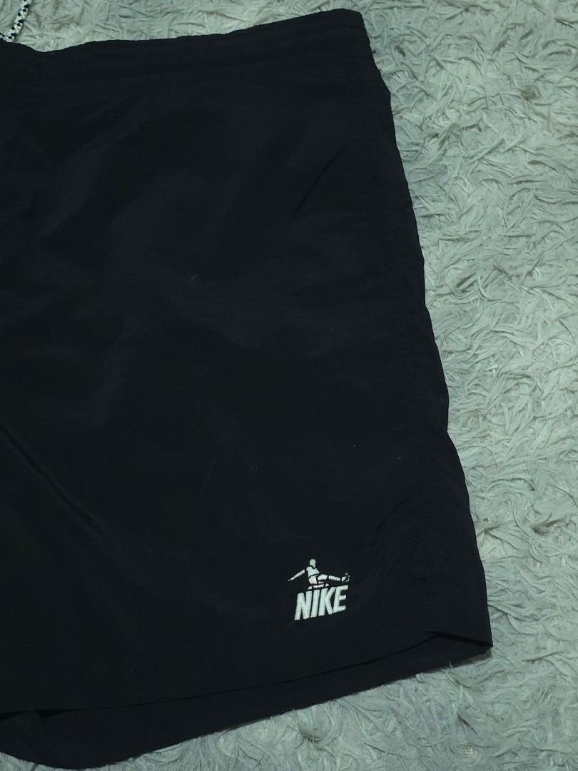 Nike Sportswear Black Shorts (Category: Shorts) located in Abulug. Submitted by humanwhosellthings (Listing ID 1468184320, Image 3). Description: - Brand: Nike Sportswear ✅Excellent Condition ✅Issue: none ▫️Waist Size: 36-40 ▫️Length: 17 - Color: Black with white, green, and grey colorblock panel - Details: White Nike logo near hem, elastic waistband with patterned drawstring - Pockets: Includes a back pocket with button closure and striped tab.