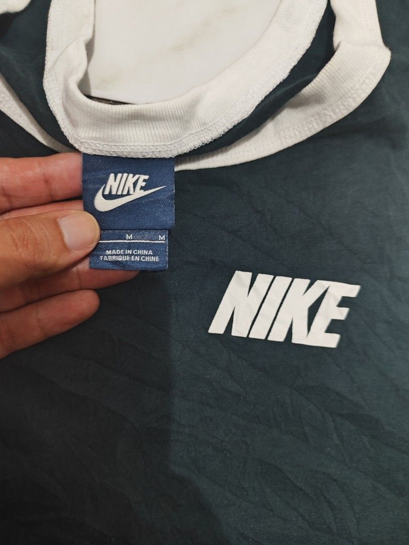 Nike tank top or sando (Category: Tshirts & Polo Shirts ) located in Tuguegarao City. Submitted by johnpetera0818 (Listing ID 1468252608, Image 2). Description: - Brand: Nike - Style: Sleeveless tank top with contrasting white ribbed collar and arm trims - Color: Dark navy / black with white printed logo on chest - Size: Medium (refer to tag) - Measurements: Approx. 19 inches across (pit-to-pit) by 28 inches down - Condition: Made in China, inclu
