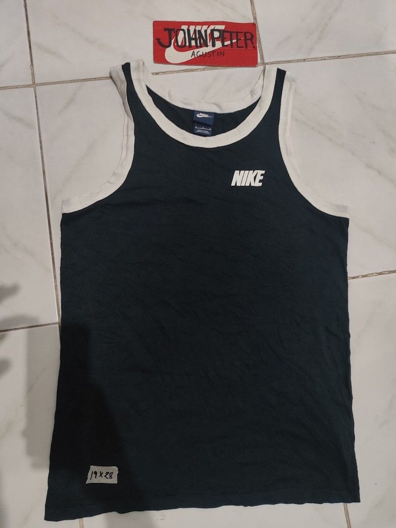 Nike tank top or sando (Category: Tshirts & Polo Shirts ) located in Tuguegarao City. Submitted by johnpetera0818 (Listing ID 1468252608, Image 1). Description: - Brand: Nike - Style: Sleeveless tank top with contrasting white ribbed collar and arm trims - Color: Dark navy / black with white printed logo on chest - Size: Medium (refer to tag) - Measurements: Approx. 19 inches across (pit-to-pit) by 28 inches down - Condition: Made in China, inclu