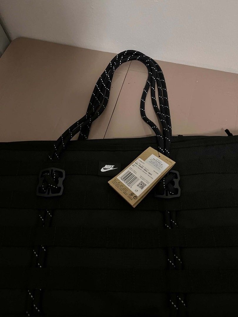 Nike Utility Tote Bag Black (Category: Tote Bags) located in Caloocan City. Submitted by savastrid (Listing ID 1468119411, Image 2). Description: - Color: All Black - Material: Heavy-duty and durable construction - Design: Modern look with exterior tactical straps, loops, and a white embroidered Nike swoosh - Straps: Sturdy dual shoulder straps accented with reflective threading - Storage: Spacious interior ideal for daily essentials, gym clothes