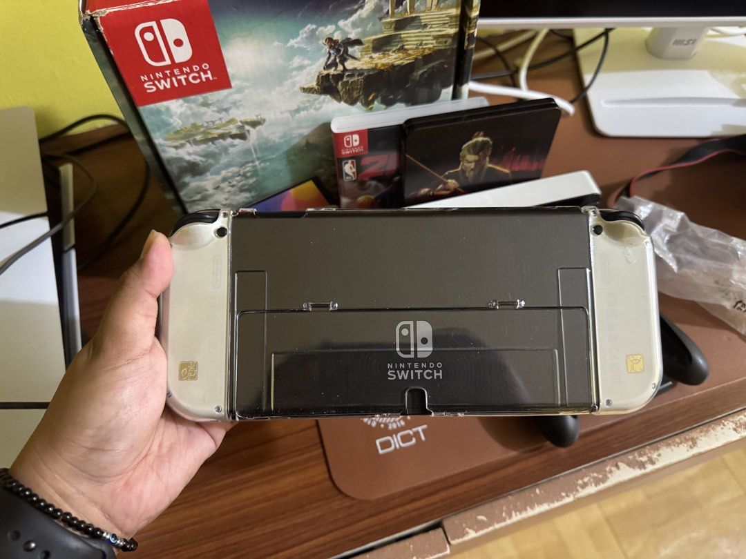 Nintendo Switch OLED Model - Zelda (Category: Nintendo) located in Quezon City. Submitted by franarizabal (Listing ID 1468253022, Image 3). Description: Nintendo Switch OLED - Zelda Tears of the Kingdom Edition - Complete with original box, dock, joy-cons, straps, and grip - Includes 256GB SanDisk microSD card - Clear protective shell case and tempered installed on console - with one free game (NBA 2k26, Sifu, or Arms) - with free DOBE case Almos