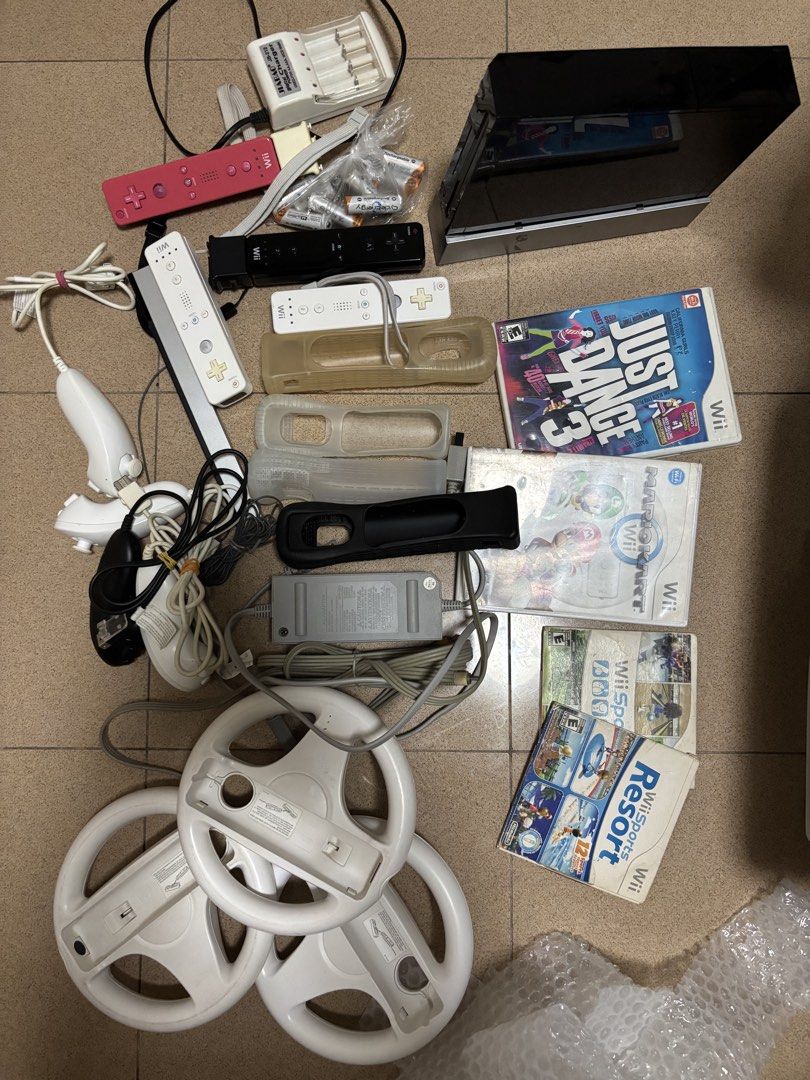 Nintendo Wii Black Console Bundle with Games and Accessories (Category: Nintendo) located in Manila. Submitted by riley523 (Listing ID 1468214365, Image 1). Description: WII FULL SET Inclusions: 1 console with stand Power cord Hdmi cord Motion sensor 2 original remote control (with additional sensor included each) 2 additional controllers 4 nunchucks 3 steering wheels Physical Games included: Mario cart Just dance 3 Wii Sports Wii sports resort F