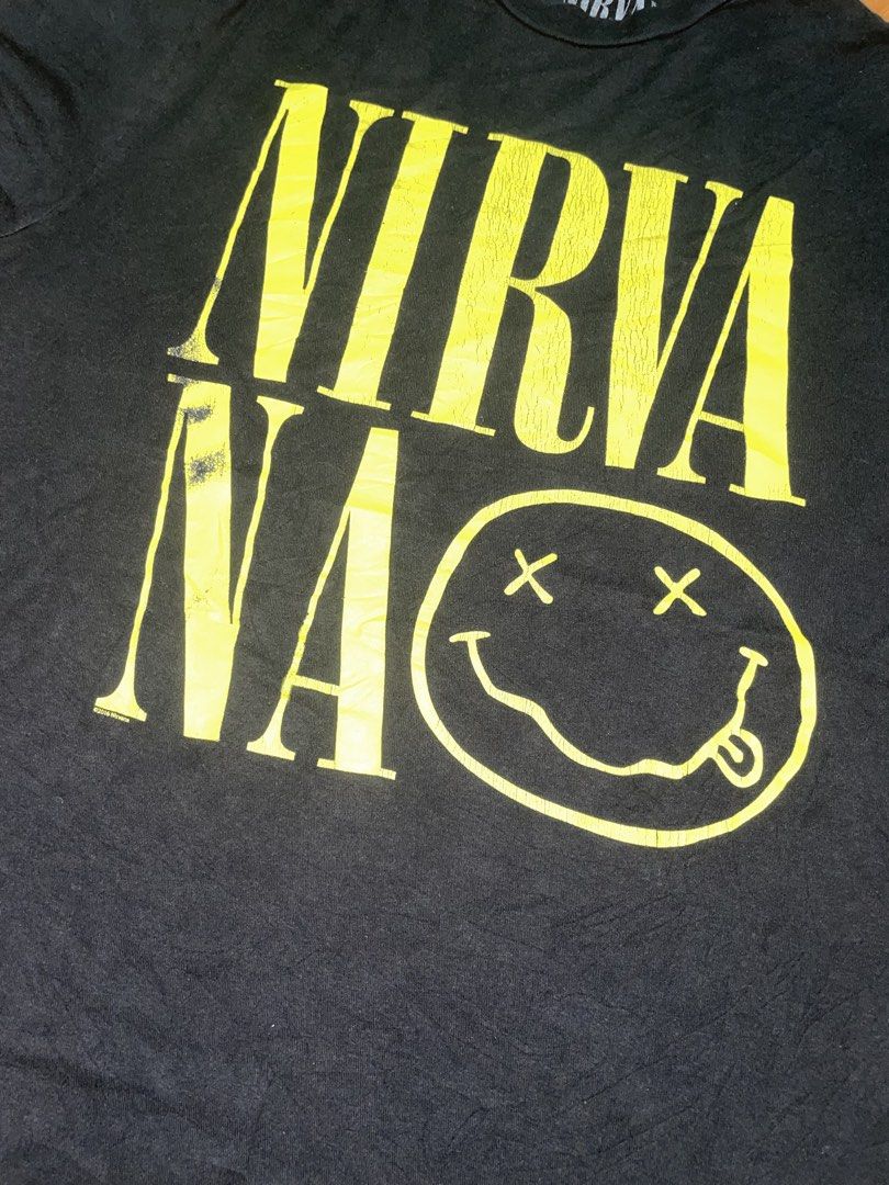 Nirvana Yellow Smiley Logo Black T-Shirt (Category: Tshirts & Polo Shirts ) located in Manila. Submitted by joshua_guimeroy. (Listing ID 1468215795, Image 2). Description: - Design: Bold yellow Nirvana typography and classic smiley face graphic on the front - Material: Comfortable cotton fabric with light, stylish cracking on the print - Fit: Short sleeves with a classic crew neck - Condition: Clean overall look, well-maintained and ready to wear