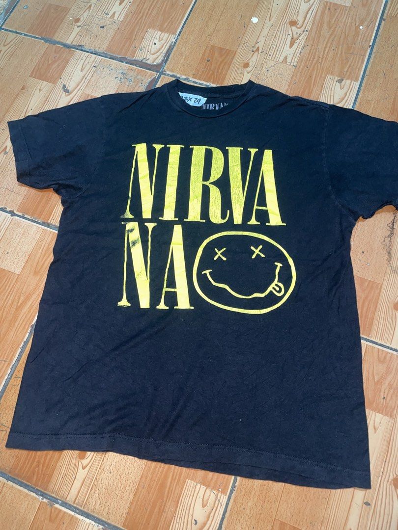Nirvana Yellow Smiley Logo Black T-Shirt (Category: Tshirts & Polo Shirts ) located in Manila. Submitted by joshua_guimeroy. (Listing ID 1468215795, Image 1). Description: - Design: Bold yellow Nirvana typography and classic smiley face graphic on the front - Material: Comfortable cotton fabric with light, stylish cracking on the print - Fit: Short sleeves with a classic crew neck - Condition: Clean overall look, well-maintained and ready to wear