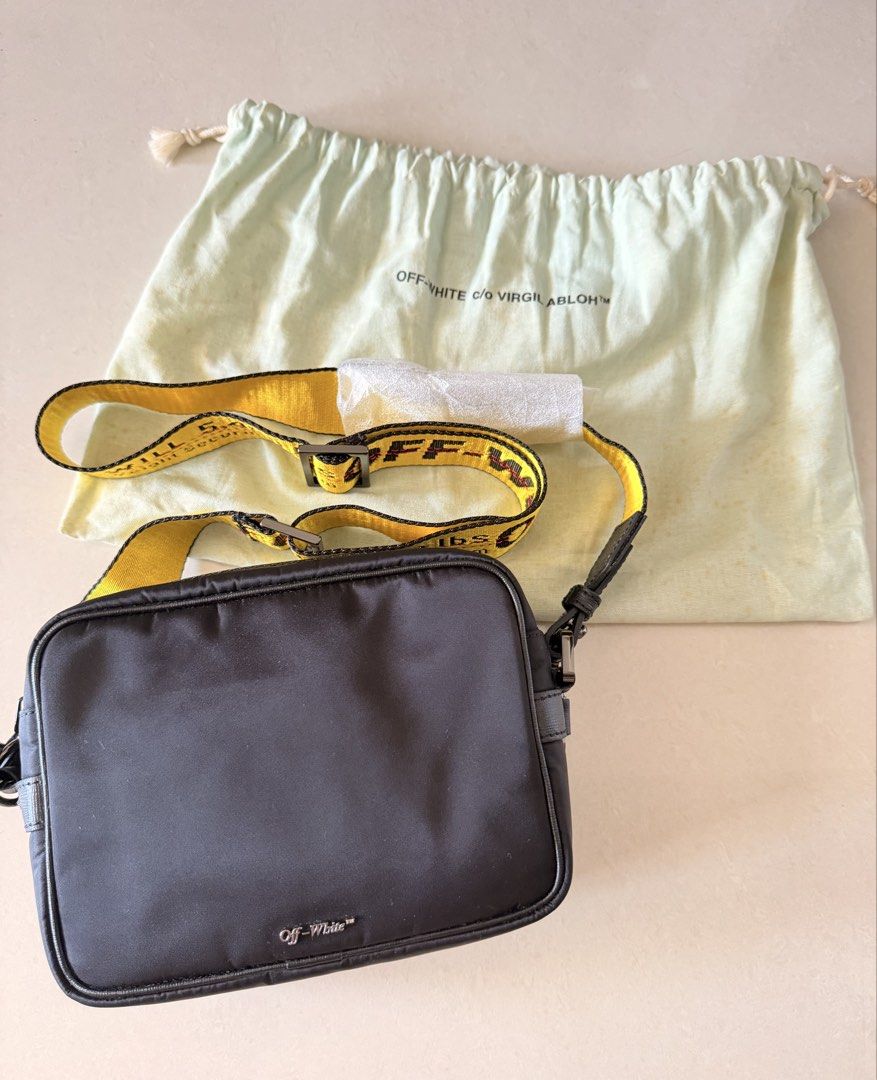 Off-White Nylon Camera Crossbody Bag with Industrial Strap (Category: Cross-body Bags) located in Manila. Submitted by shopbureau (Listing ID 1468096068, Image 1). Description: - Brand: Off-White - Material: Durable black nylon - Strap: Signature yellow industrial strap with black lettering - Hardware & Closure: Silver-tone hardware with secure zip closure - Details: Small front logo print and interior main label tag - Condition: Minimal wear, ex