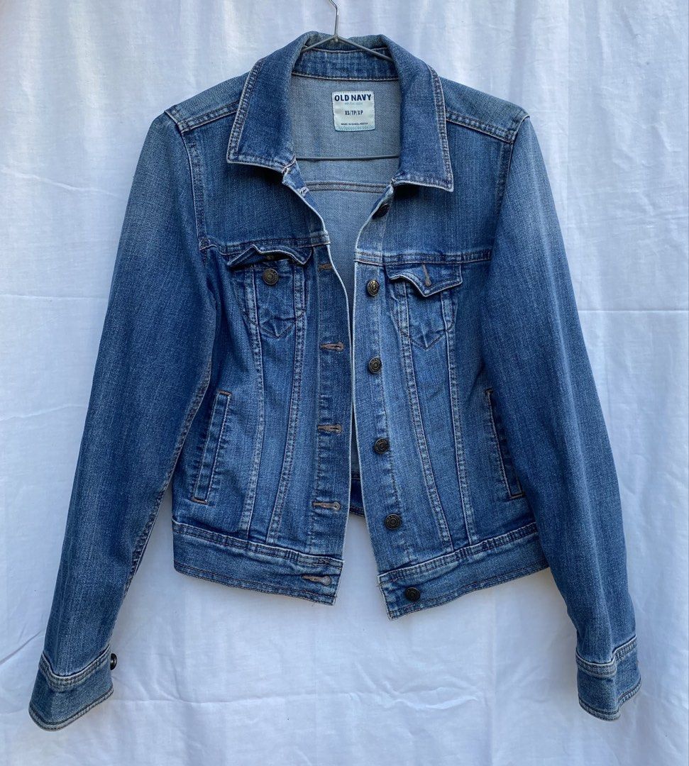 Old Navy Blue Denim Jacket XS (Category: Coats, Jackets and Outerwear) located in Baguio. Submitted by royalriver17 (Listing ID 1468222348, Image 1). Description: - Brand: Old Navy - Size: XS (Made in Bangladesh) - Color/Wash: Classic medium blue with slight fading - Style: Traditional trucker jacket - Details: Front button closure, chest flap pockets, side welt pockets, and tan contrast stitching - Condition: Sturdy denim with a broken-in look.