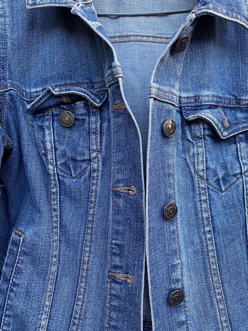 Old Navy Blue Denim Jacket XS (Category: Coats, Jackets and Outerwear) located in Baguio. Submitted by royalriver17 (Listing ID 1468222348, Image 2). Description: - Brand: Old Navy - Size: XS (Made in Bangladesh) - Color/Wash: Classic medium blue with slight fading - Style: Traditional trucker jacket - Details: Front button closure, chest flap pockets, side welt pockets, and tan contrast stitching - Condition: Sturdy denim with a broken-in look.