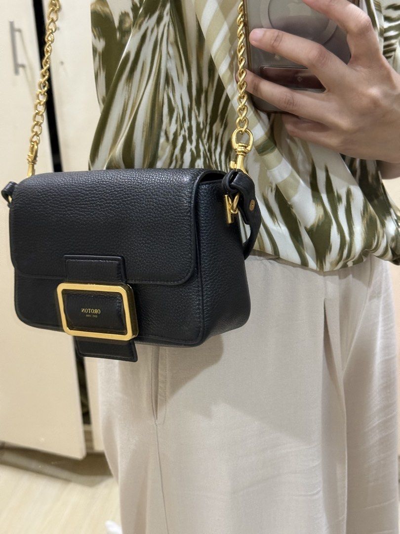 Oroton Astrid Crossbody Bag Black (Category: Cross-body Bags) located in Taguig. Submitted by preloved.by.diane (Listing ID 1468242701, Image 2). Description: - Brand: Oroton - Style: Astrid Crossbody - Material: Black pebble leather - Hardware: Gold - Closure: Front buckle with magnetic snap - Strap: Adjustable chain and leather - Interior: Clean lining with open main compartment - Condition: Brand new, unused with original $399 tag attached.