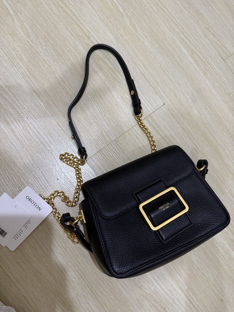 Oroton Astrid Crossbody Bag Black (Category: Cross-body Bags) located in Taguig. Submitted by preloved.by.diane (Listing ID 1468242701, Image 1). Description: - Brand: Oroton - Style: Astrid Crossbody - Material: Black pebble leather - Hardware: Gold - Closure: Front buckle with magnetic snap - Strap: Adjustable chain and leather - Interior: Clean lining with open main compartment - Condition: Brand new, unused with original $399 tag attached.