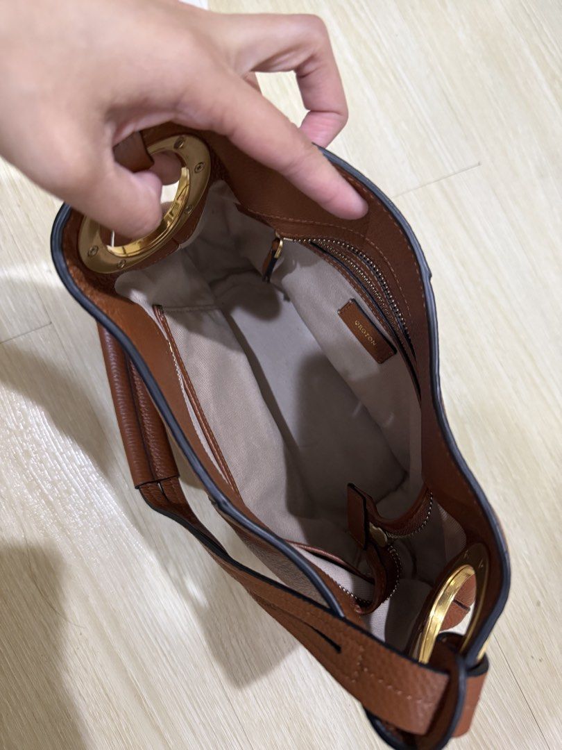Oroton Brown Leather Shoulder Bag (Category: Shoulder Bags) located in Taguig. Submitted by preloved.by.diane (Listing ID 1468243156, Image 2). Description: Brown pebble leather shoulder bag from Oroton. Gold hardware accents on the side rings. Zip pocket inside with clean fabric lining. Structured base, comfortably hangs under the arm. Classic everyday purse with plenty of room for daily essentials..
