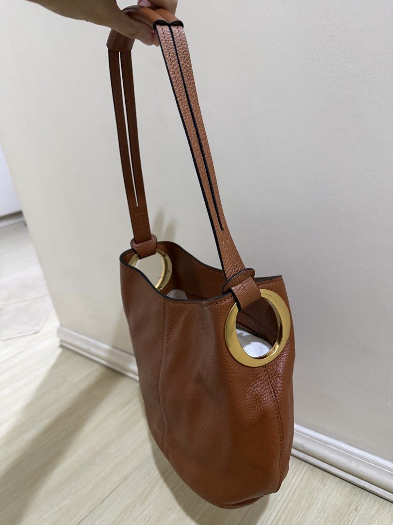 Oroton Brown Leather Shoulder Bag (Category: Shoulder Bags) located in Taguig. Submitted by preloved.by.diane (Listing ID 1468243156, Image 3). Description: Brown pebble leather shoulder bag from Oroton. Gold hardware accents on the side rings. Zip pocket inside with clean fabric lining. Structured base, comfortably hangs under the arm. Classic everyday purse with plenty of room for daily essentials..