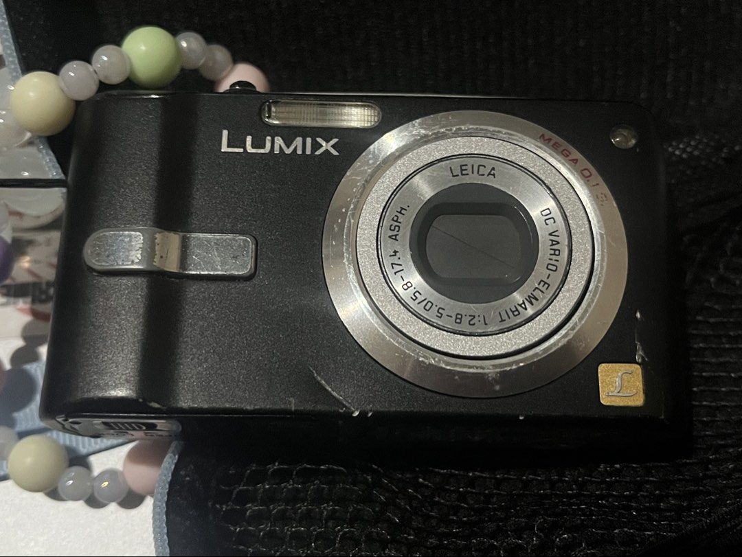 Panasonic Lumix Digicam with Charger & Case (Category: Cameras) located in Manila. Submitted by ymgucci (Listing ID 1468186430, Image 3). Description: • Brand: Panasonic Lumix Camera • Lens: Leica DC Vario-Elmarit lens • Condition: Black body with visible cosmetic scratches and wear marks from regular handling; tested and powers up fine • Does NOT come with an SD card, but comes with the battery • Included Accessories: Protective carrying case, m