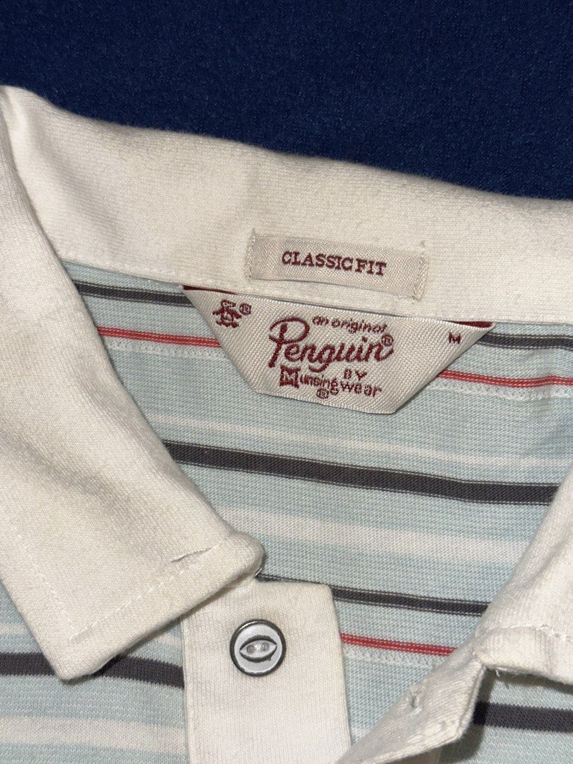 Penguin polo shirt (Category: Tshirts & Polo Shirts ) located in Quezon City. Submitted by mancave_stuff (Listing ID 1468163526, Image 3). Description: Light blue and multi-stripe short-sleeve polo shirt from Original Penguin by Munsingwear, featuring a white collar, button placket, and the brand’s signature embroidered penguin logo on the chest. Size M: W19” x L26” Very good condition .