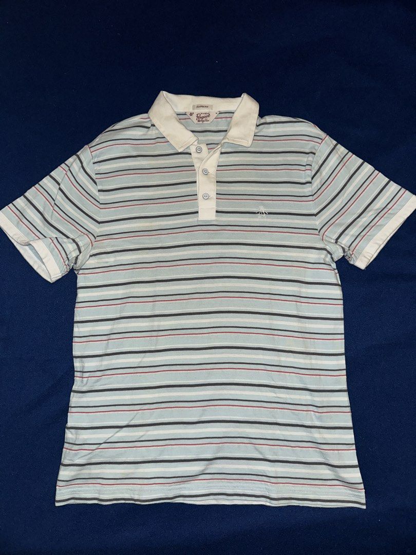 Penguin polo shirt (Category: Tshirts & Polo Shirts ) located in Quezon City. Submitted by mancave_stuff (Listing ID 1468163526, Image 1). Description: Light blue and multi-stripe short-sleeve polo shirt from Original Penguin by Munsingwear, featuring a white collar, button placket, and the brand’s signature embroidered penguin logo on the chest. Size M: W19” x L26” Very good condition .
