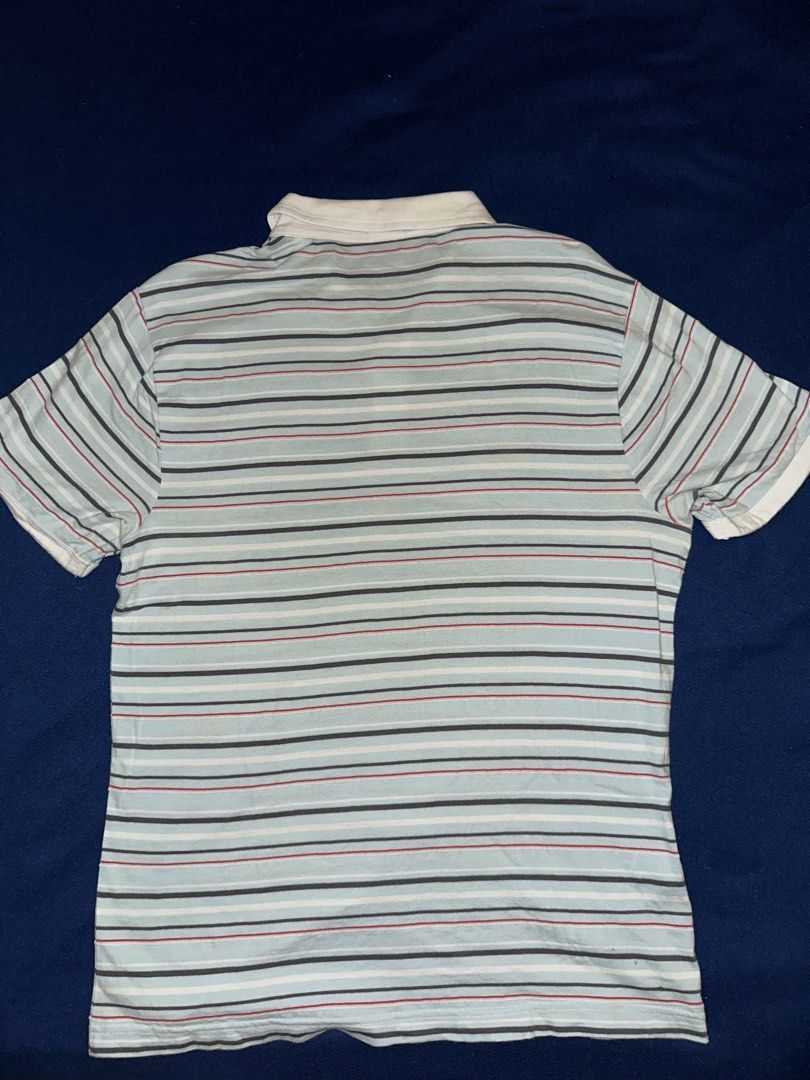 Penguin polo shirt (Category: Tshirts & Polo Shirts ) located in Quezon City. Submitted by mancave_stuff (Listing ID 1468163526, Image 2). Description: Light blue and multi-stripe short-sleeve polo shirt from Original Penguin by Munsingwear, featuring a white collar, button placket, and the brand’s signature embroidered penguin logo on the chest. Size M: W19” x L26” Very good condition .