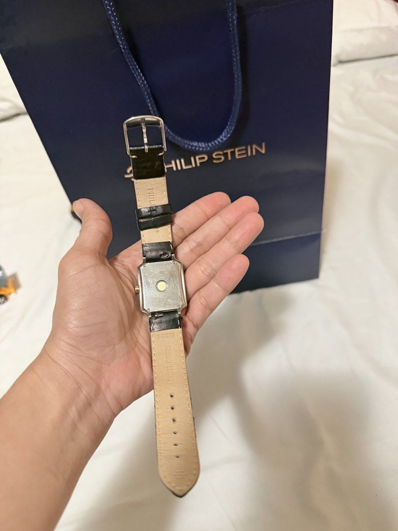 Philip Stein Watch Black Leather Strap (Category: Women's Watches) located in Cebu City. Submitted by jocapin32 (Listing ID 1468164940, Image 3). Description: - Authentic Philip Stein wristwatch with a sleek rectangular white dial - Silver-tone case complemented by a stylish gold crown - Black genuine leather strap with chic white contrast stitching - Clean, scratch-free crystal and fully functional dial markers - Includes original gift bag, and 