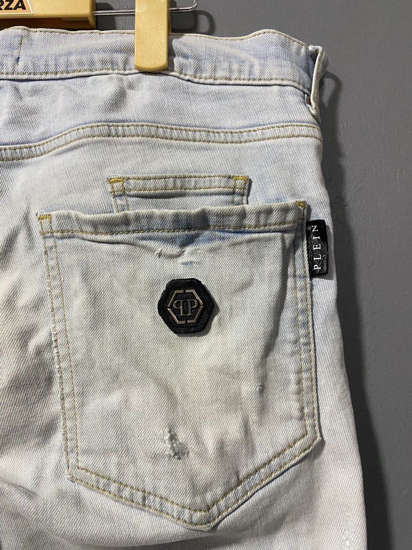 Philipp Plein Biker Distressed Light Wash Jeans (Category: Jeans) located in Tanay. Submitted by judevalcorza (Listing ID 1468224507, Image 3). Description: - Brand: Authentic Philipp Plein Biker ice Cube - Style: Biker jeans with heavy distressing and ripped knees - Details: Striped blue patches underneath rips, multiple zip accents, and black woven pull tabs - Hardware: Branded hardware, skull zip pulls on front pockets, and hexagonal logo plat
