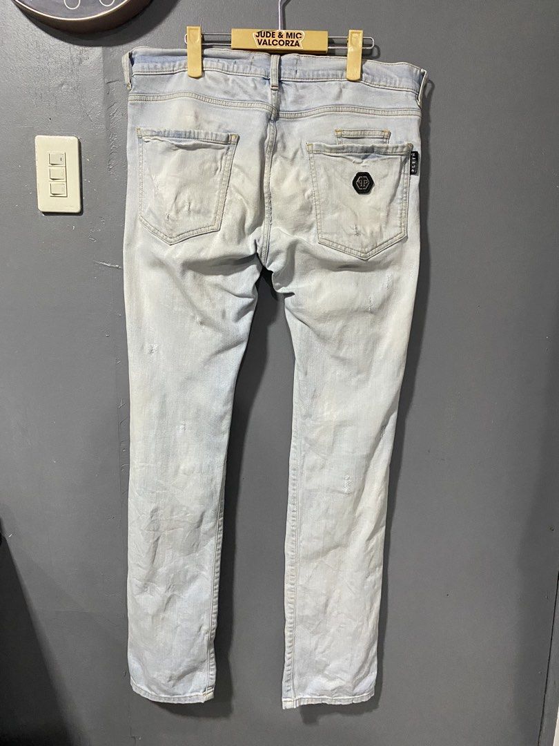 Philipp Plein Biker Distressed Light Wash Jeans (Category: Jeans) located in Tanay. Submitted by judevalcorza (Listing ID 1468224507, Image 2). Description: - Brand: Authentic Philipp Plein Biker ice Cube - Style: Biker jeans with heavy distressing and ripped knees - Details: Striped blue patches underneath rips, multiple zip accents, and black woven pull tabs - Hardware: Branded hardware, skull zip pulls on front pockets, and hexagonal logo plat