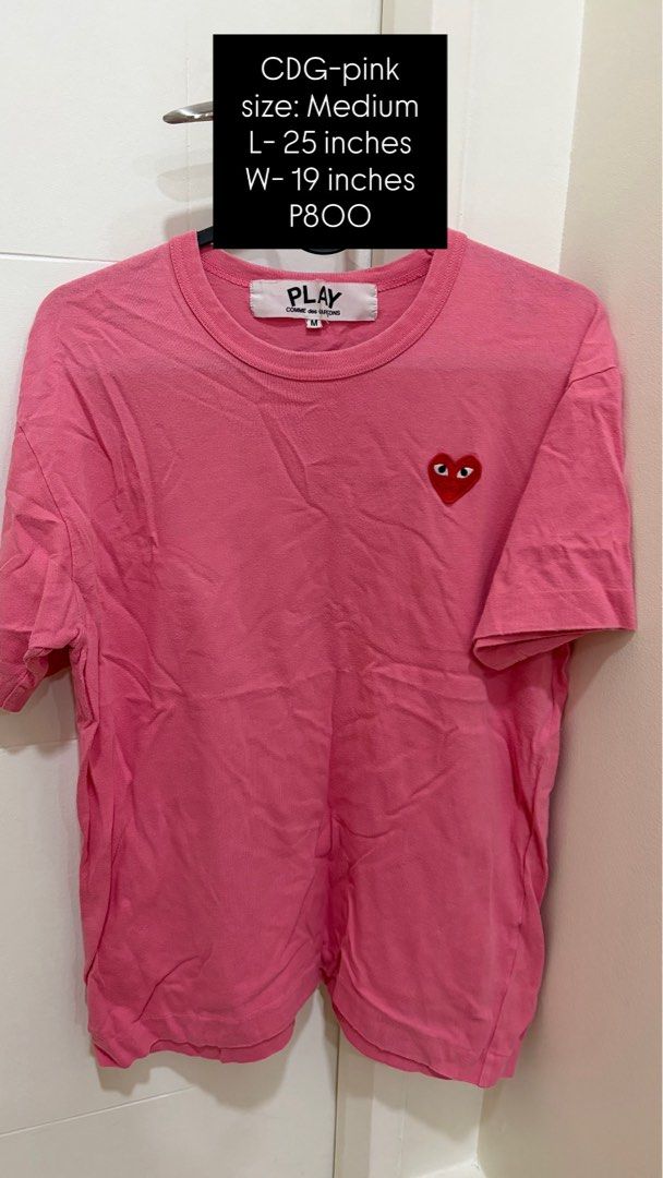 PLAY Comme des Garçons Pink T-Shirt Size Medium (Category: Shirts) located in Pasig City. Submitted by sheencf (Listing ID 1468187798, Image 1). Description: - Brand: PLAY Comme des Garçons - Item: Pink t-shirt with signature red heart logo - Size: Medium (Length: 25 inches, Width: 19 inches) - Material: 100% Cotton - Design: Classic crew neck, short sleeves, vibrant pink color - Condition: Great casual staple, easy to style with jeans or skirts 