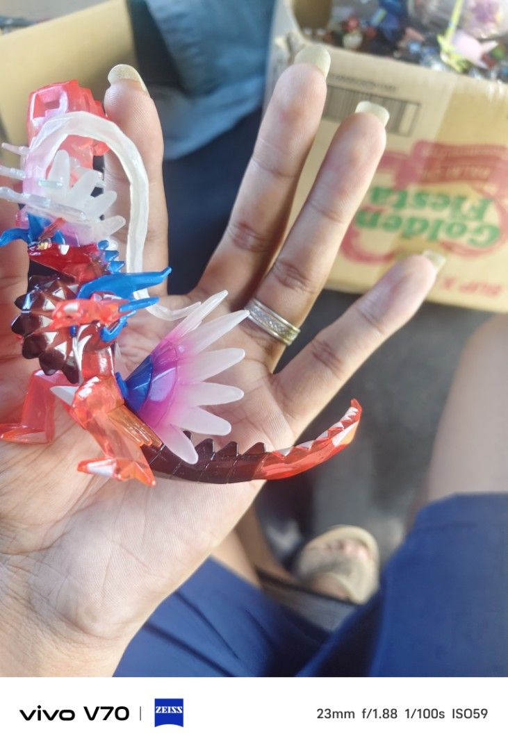 Pokémon Koraidon Terastal Phenomenon Figure (Category: Figurines & Statues) located in Kapangan. Submitted by ClumZyDale (Listing ID 1468082721, Image 1). Description: - Authentic Pokémon Koraidon display figure - Features striking translucent red, white, and blue crystal details - Clear plastic effect parts on the head and tail for a dynamic look - Intricately sculpted scales and spikes along the back - Perfect size for desktop or shelf display 