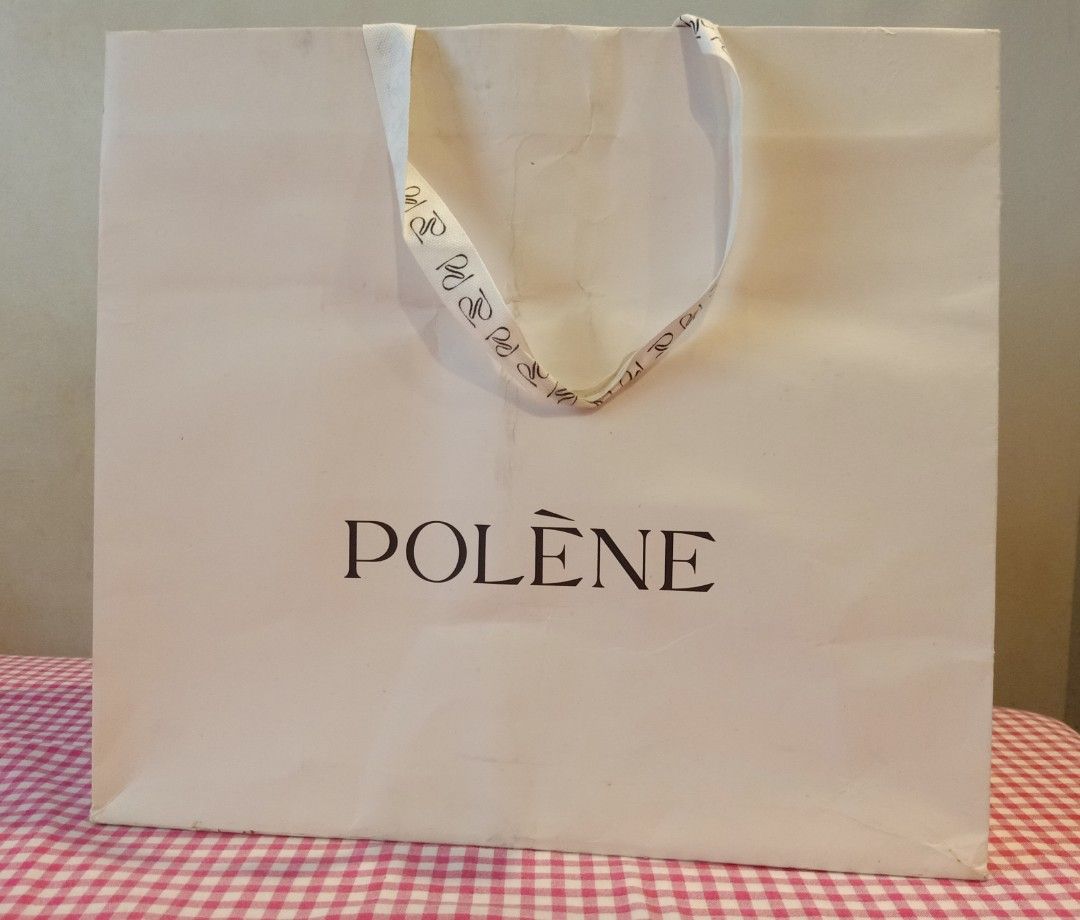 Polène Paper Shopping Bag Gift Bag (Category: Tote Bags) located in Cainta. Submitted by belli_phats (Listing ID 1468090891, Image 2). Description: - Authentic Polène paper shopping bag - Elegant cream exterior with black brand logo - Stylish fabric handles with repeating logo monogram pattern - Sturdy paper construction with a folded bottom gusset - Perfect for gifting, organizing, or collection storage.