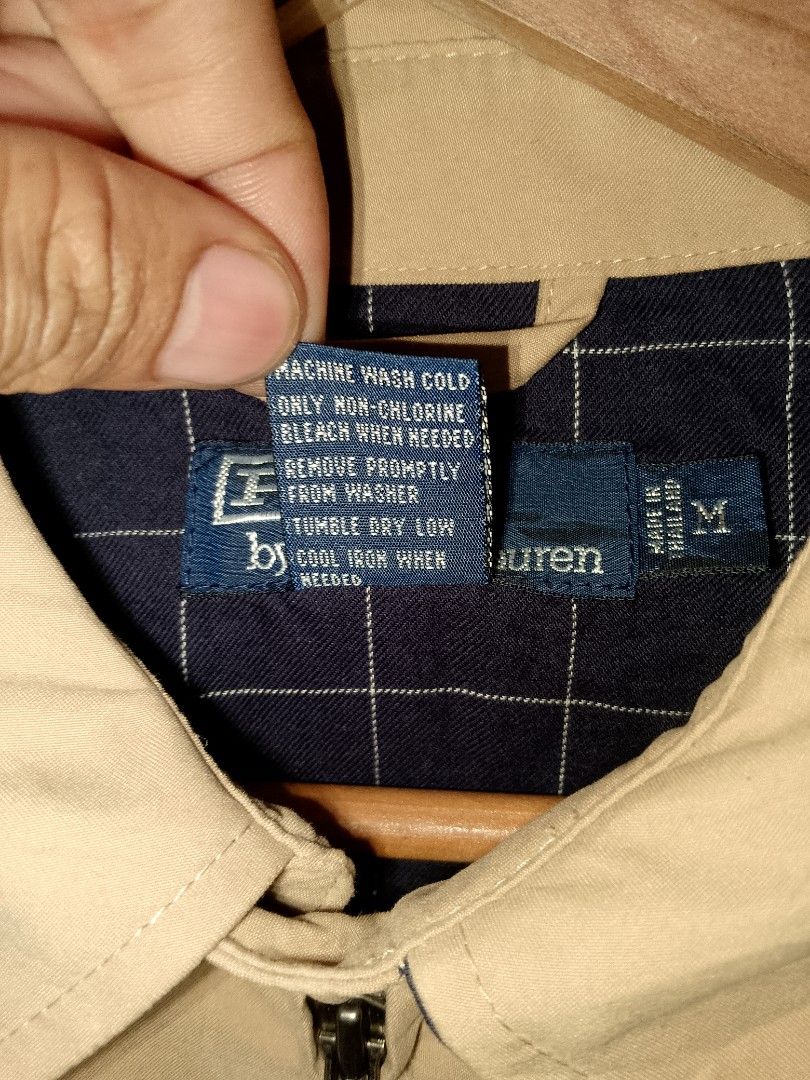 Polo Ralph Lauren Tan Zip-Up Jacket Size M (Category: Coats, Jackets and Outerwear) located in Manila. Submitted by mjthrifted_second (Listing ID 1468086749, Image 3). Description: - Brand: Polo Ralph Lauren - Style: Tan zip-up jacket - Size: M (Made in Thailand) -Dimes: 24/26 - Materials: 100% polyester shell, 100% cotton body lining, 100% polyester sleeve lining - Details: Classic blue embroidered pony logo on chest, stylish navy plaid inner li