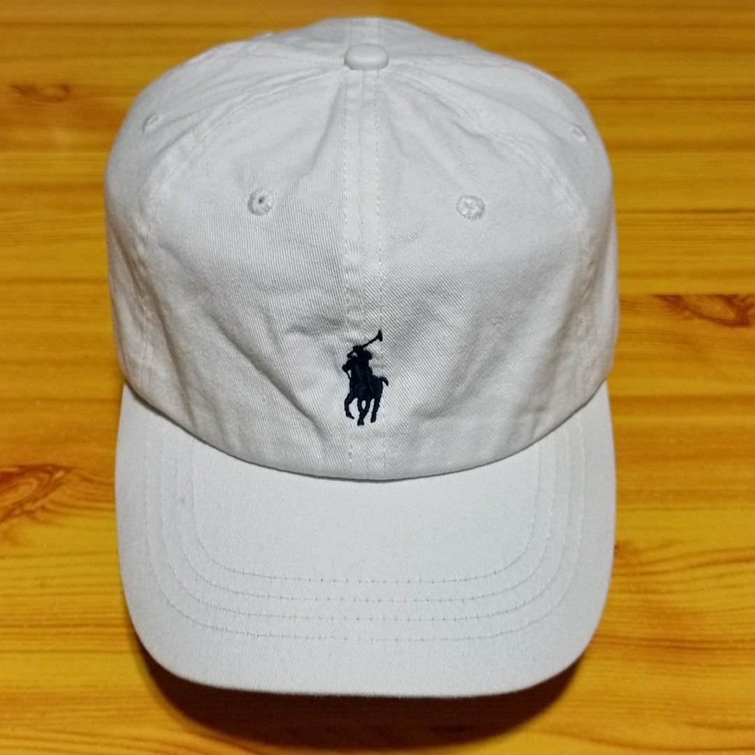 Polo Ralph Lauren White Baseball Cap (Category: Caps & Hats) located in Manila. Submitted by caps08 (Listing ID 1468257658, Image 2). Description: - Brand: Polo Ralph Lauren - Color: Classic White with Navy Blue embroidered pony logo - Material: 100% clean cotton - Fit: Adjustable metal strap closure with Polo branding - Condition: Brand new / Excellent - Perfect for daily casual wear and sun protection.