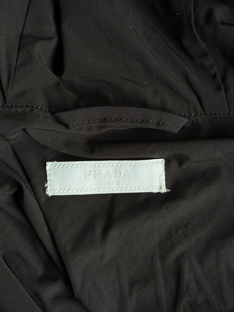 Prada Black Hooded Windbreaker Jacket (Category: Coats, Jackets and Outerwear) located in Kibawe. Submitted by jeloots (Listing ID 1468086000, Image 2). Description: - Authentic Black Prada Hooded Windbreaker (Size L, Made in Italy) - Features iconic rubberized triangle logo patch on the chest - Secure zip closure with zipped front pockets - Adjustable drawstring hood with Prada-stamped metallic hardware - Stylish elastic cuffs with signature bra
