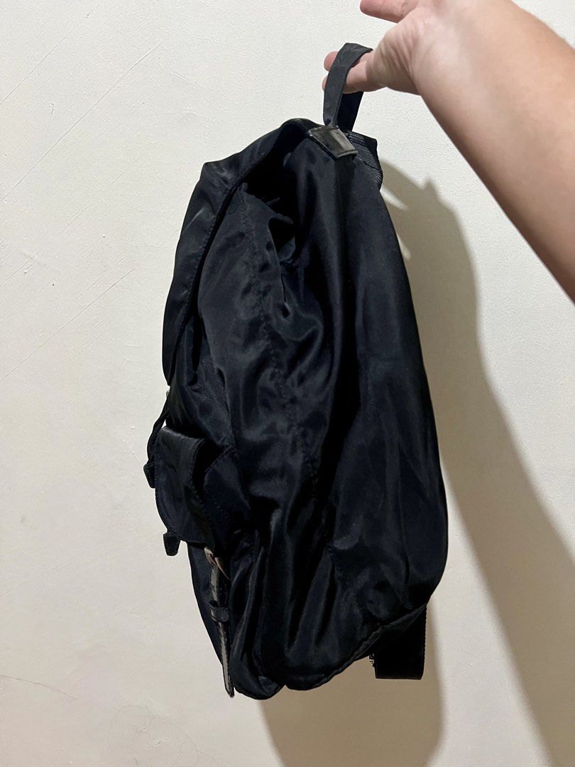 Authentic Prada Black Nylon Backpack (Category: Luxury Bags & Wallets) located in Dagupan City. Submitted by casadebayongph (Listing ID 1468221405, Image 3). Description: Black nylon Prada backpack. Classic triangle logo badge on the front flap. Drawstring closure with buckled front straps. Two front pockets with buckled flaps. Adjustable black webbed shoulder straps and top handle. Silver-tone hardware throughout. Clean interior and exterior. Cu