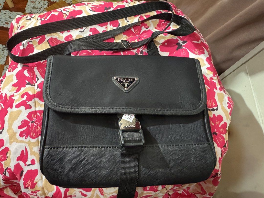 Prada Black Nylon Messenger Bag Crossbody (Category: Luxury Bags & Wallets) located in Manila. Submitted by wildbear.e10374 (Listing ID 1468093268, Image 1). Description: Black Prada crossbody bag made of durable nylon and Saffiano leather trim. Features an iconic triangular Prada metal logo on the front flap and a branded metal buckle closure. Adjustable black shoulder strap included. Back side includes a clear window pocket for ID or cards. Sho