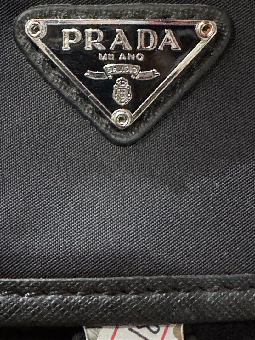 Prada Black Nylon Messenger Bag Crossbody (Category: Luxury Bags & Wallets) located in Manila. Submitted by wildbear.e10374 (Listing ID 1468093268, Image 2). Description: Black Prada crossbody bag made of durable nylon and Saffiano leather trim. Features an iconic triangular Prada metal logo on the front flap and a branded metal buckle closure. Adjustable black shoulder strap included. Back side includes a clear window pocket for ID or cards. Sho