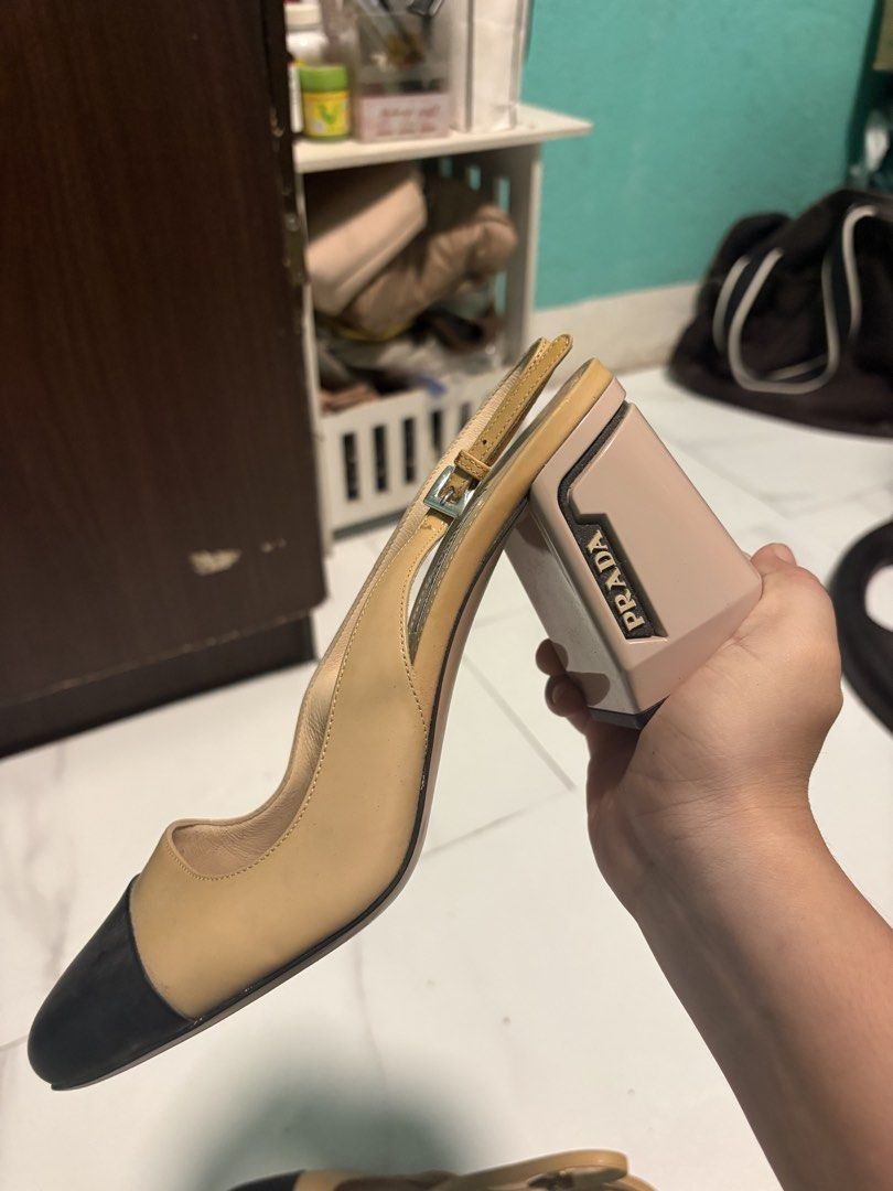 Prada Block Heel Slingback Pumps Nude Black (Category: Heels) located in San Quintin. Submitted by angelcabarloc (Listing ID 1468235154, Image 1). Description: - Brand: Prada - Style: Colorblock slingback heels with chunky block heels - Material: Nude leather with black cap toes - Details: Features the Prada logo on the heel and an adjustable buckle ankle strap - Condition: Light creasing on the leather and some wear on the soles - Perfect timele