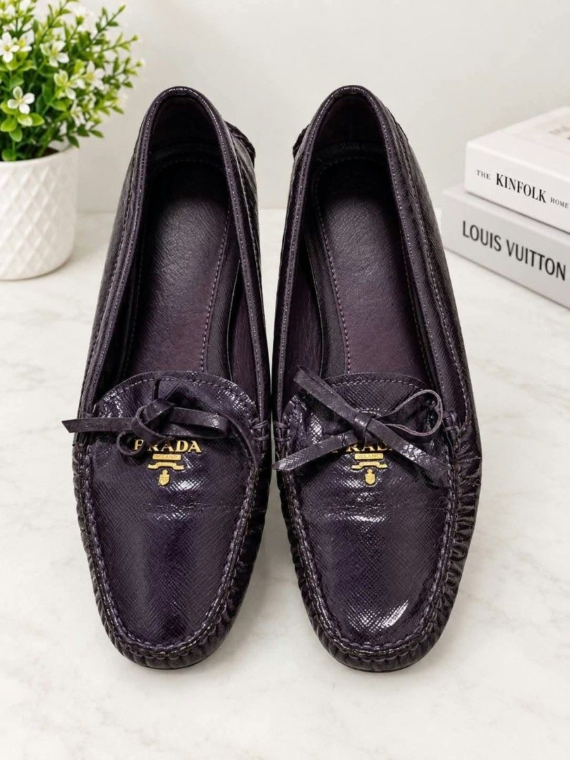 Prada Purple Saffiano Leather (Category: Sneakers & Footwear) located in Lucena. Submitted by amirahsoonlineshop (Listing ID 1468076053, Image 2). Description: - Brand: Prada - Color: Purple - Material: Patent leather with Saffiano texture - Size: 38.5 - Design: Dainty front bow with gold-tone Prada Milano metal logo - Soles: Rubber driving soles for added grip - Interior: Clean purple lining - Style: Everyday slip-on loafers.