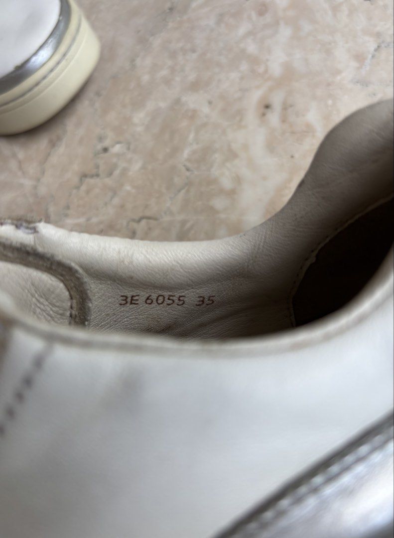Prada Sport Leather Sneakers (Category: Sneakers) located in Caloocan City. Submitted by dgzzz (Listing ID 1468141993, Image 3). Description: - Brand: Prada - Item: White Leather Sneakers with Silver Metallic Trim - Size: EU 35 (Style Code: 3E 6055) - Details: Embossed Prada logo on tongue, debossed lettering on rubber heel - Condition: Minor wear on soles and gentle leather creases from normal use - Authenticity guaranteed, perfect for elevated 