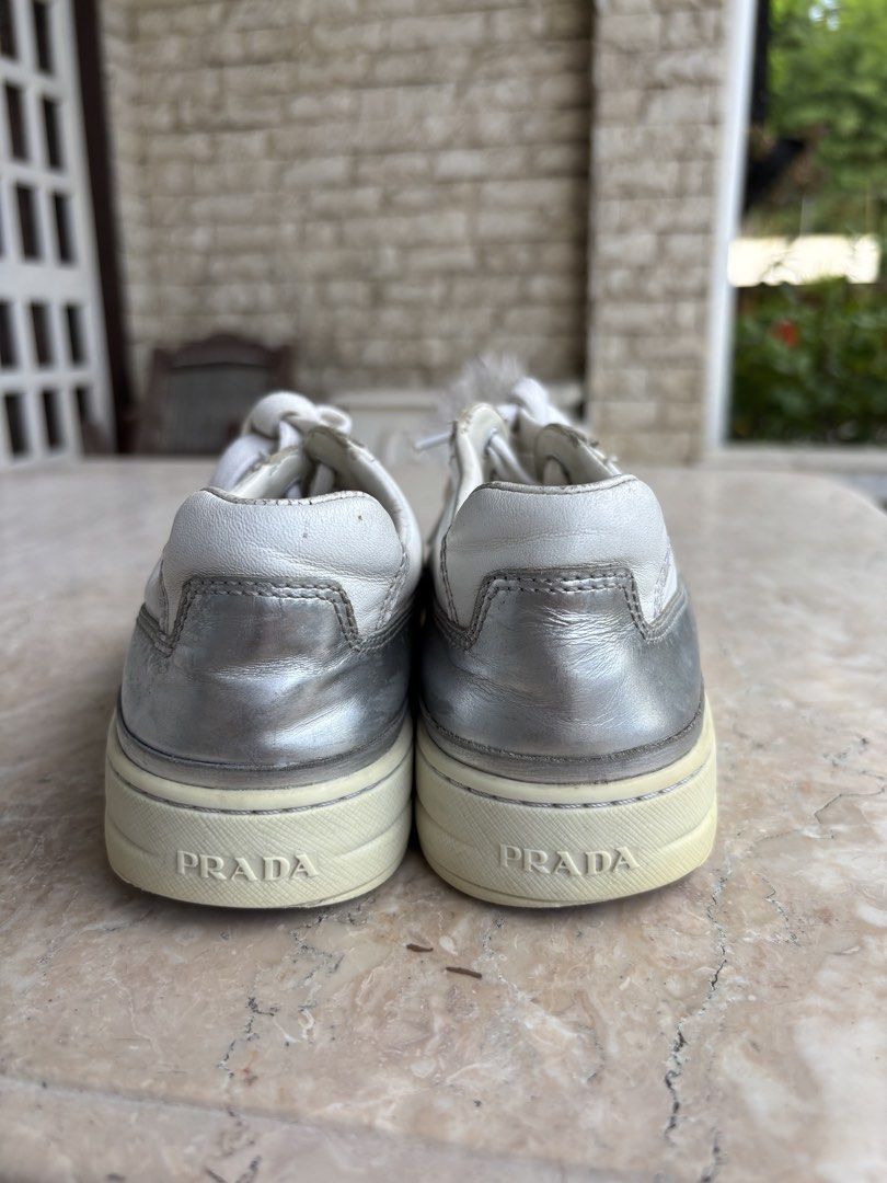 Prada Sport Leather Sneakers (Category: Sneakers) located in Caloocan City. Submitted by dgzzz (Listing ID 1468141993, Image 2). Description: - Brand: Prada - Item: White Leather Sneakers with Silver Metallic Trim - Size: EU 35 (Style Code: 3E 6055) - Details: Embossed Prada logo on tongue, debossed lettering on rubber heel - Condition: Minor wear on soles and gentle leather creases from normal use - Authenticity guaranteed, perfect for elevated 