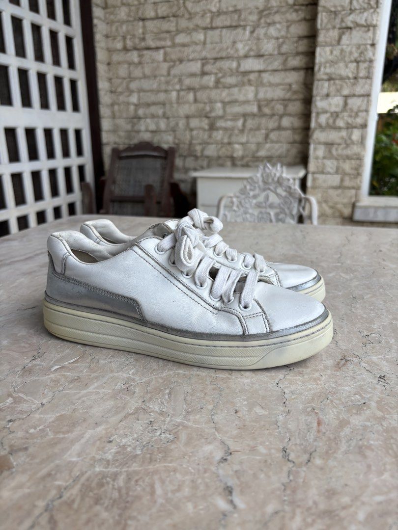 Prada Sport Leather Sneakers (Category: Sneakers) located in Caloocan City. Submitted by dgzzz (Listing ID 1468141993, Image 1). Description: - Brand: Prada - Item: White Leather Sneakers with Silver Metallic Trim - Size: EU 35 (Style Code: 3E 6055) - Details: Embossed Prada logo on tongue, debossed lettering on rubber heel - Condition: Minor wear on soles and gentle leather creases from normal use - Authenticity guaranteed, perfect for elevated 
