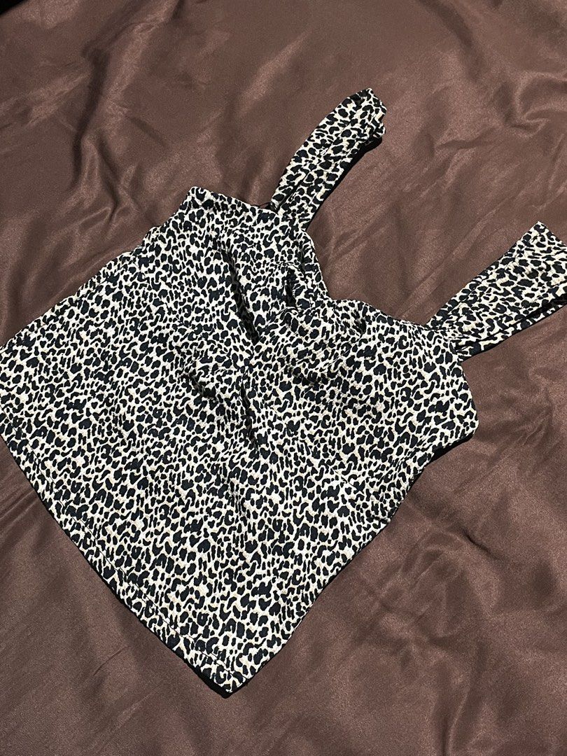 PRIMARK Animal Top Size XS (Category: Sleeveless) located in Manila. Submitted by maaya.rikit (Listing ID 1468104345, Image 2). Description: - Brand: Primark - Size: XS - Pattern: Black and white leopard print - Design: Square neckline, thick straps, and front knot detail - Fit: Cropped length, soft, and stretchy fabric.
