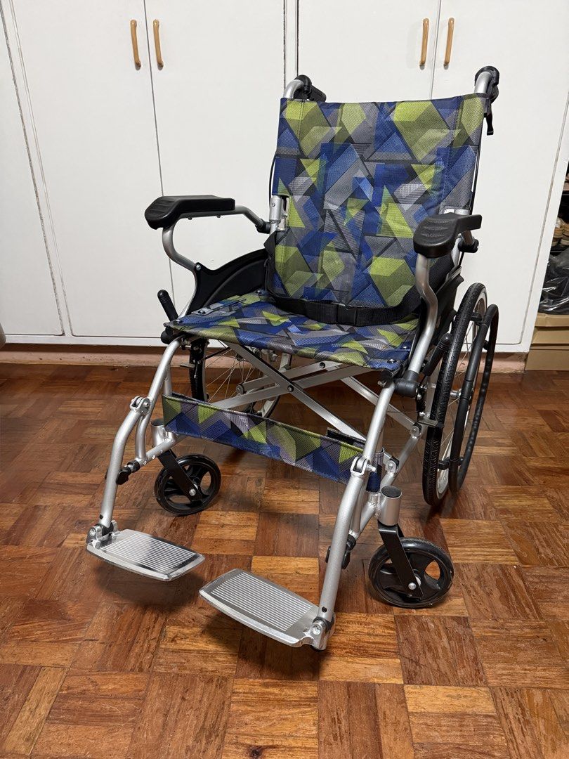 Procare Aluminum Lightweight Foldable Wheelchair (Category: Wheelchairs) located in Manila. Submitted by caliyafinds (Listing ID 1468228778, Image 2). Description: - Brand: Procare - Design: blue and green geometric pattern - Frame: Lightweight silver aluminum - Safety & Control: Integrated handbrakes on pushing handles and seatbelt included - Comfort Features: 46cm seat width, fixed armrests, flip-up footrests, 20 inches back wheels, compact - S