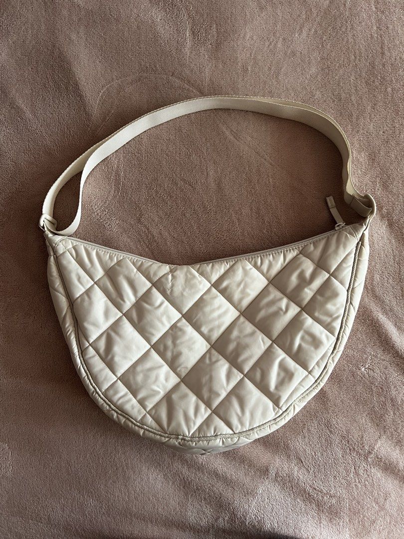 Quilted Crescent Shoulder Bag Cream (Category: Cross-body Bags) located in Muntinlupa City. Submitted by micaela23235418 (Listing ID 1468061300, Image 1). Description: Selling an authentic Uniqlo padded shoulder bag in versatile off-white. In good condition. This is the larger sized bag, great for traveling and holds a lot. From widest point (lengthwise) it’s 38cm. RFS: not using it.