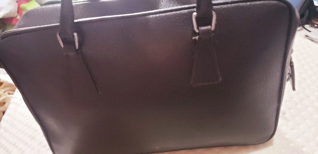 RARE Prada Black Leather Briefcase Handbag (Category: Luxury Bags & Wallets) located in Marikina City. Submitted by racoon143 (Listing ID 1468115370, Image 3). Description: - Material: Premium black textured leather with silver-tone hardware - Design: Structured rectangular shape with clean lines - Features: Secure zipper closure, padlock included, and reinforced top handles - Capacity: Spacious interior for documents and daily essentials - Style