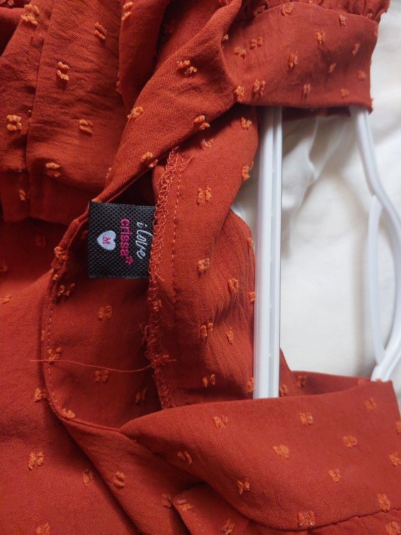 Crissa Swiss Dot Square Neck Blouse with Ruffled by Straps (Category: Blouses) located in Pasig City. Submitted by salazaralona (Listing ID 1468066813, Image 3). Description: - Color: Rusty red with all-over dotted texture - Neckline & Straps: Square neckline with playful ruffled shoulder straps - Sleeves: Half sleeves - Closure: Functional front button closure - Details: Gathered yoke across the chest - Material: Lightweight and breathable - Sty