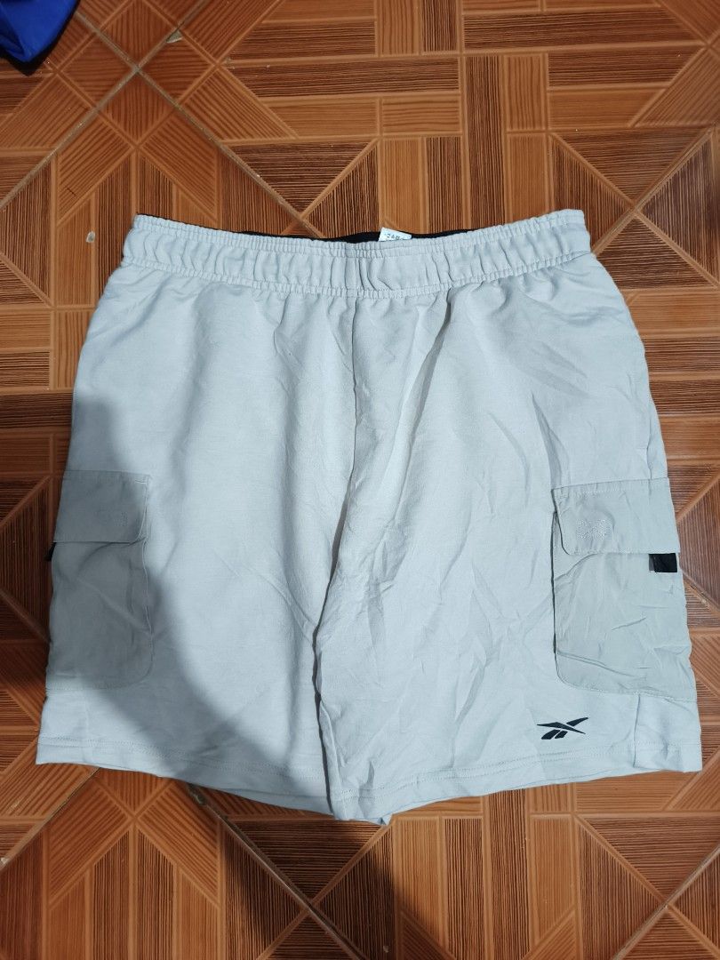 Reebok Cargo Shorts Light Grey Size M (Category: Shorts) located in Manila. Submitted by dyastenthrift (Listing ID 1468163341, Image 1). Description: - Brand: Reebok - Style: Cargo Shorts - Color: Light Grey - Size: Medium - Waistband: Elastic with branded black inner band and adjustable drawstring - Pockets: Large cargo pockets on both legs - Details: Small embroidered logo near the hem - Origin: Made in Cambodia - Condition: Great for casual ev