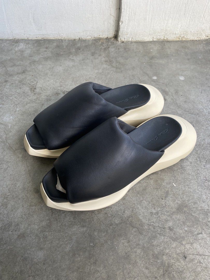 Rick Owens Geth Puffer Slides (Category: Slippers & Slides) located in Cavite. Submitted by benta_bounce (Listing ID 1468077950, Image 3). Description: - Brand: Rick Owens - Style: Padded slides / slip-on - Color: Black leather upper with milk white sole - Sole: Distinctive thick shark tooth design - Branding: Debossed signature on footbed and outsole - Details: Structured puffed upper strap - Condition: like new, unworn, zero wear on soles, pape